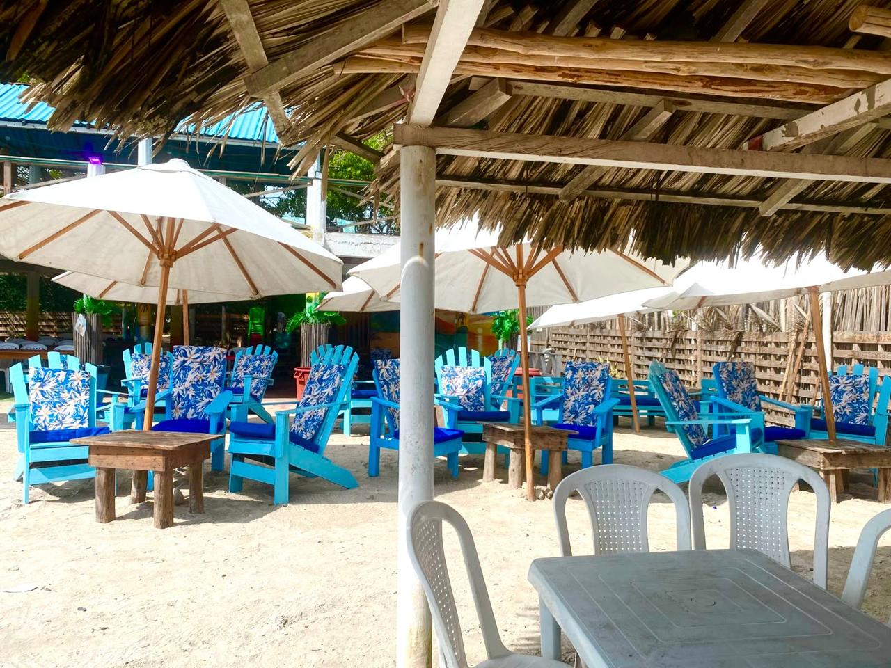 Zona de descanso con sillas y sombrillas en Marasú Beach Club